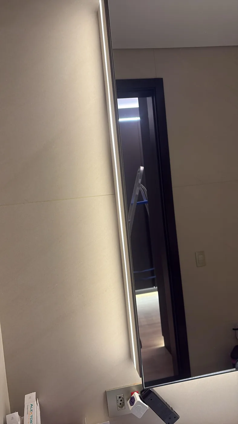 Detalhe de iluminação em espelho e tomada instalada